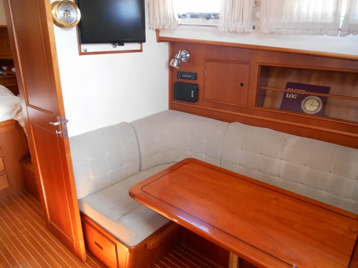 Balmy Yacht Photos Pics Interior of 1999 Grand Banks 38 Eastbay EX with wooden table and cushioned seating.