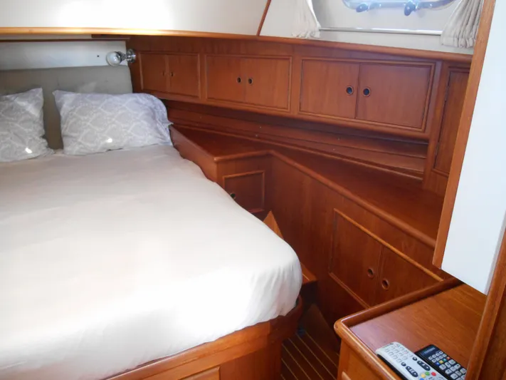 Balmy Yacht Photos Pics Cozy cabin interior of 1999 Grand Banks 38 Eastbay EX with wooden cabinetry and bed.