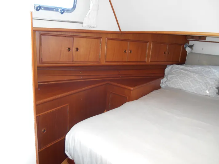 Balmy Yacht Photos Pics 1999 Grand Banks 38 Eastbay EX cabin with wooden cabinetry and a cozy bed.