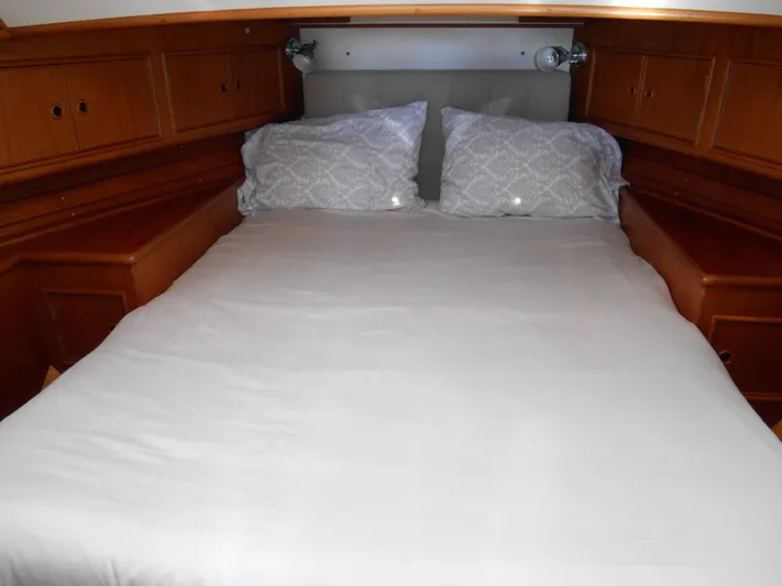 Balmy Yacht Photos Pics Cozy cabin bed in 1999 Grand Banks 38 Eastbay EX yacht, featuring wooden cabinetry.