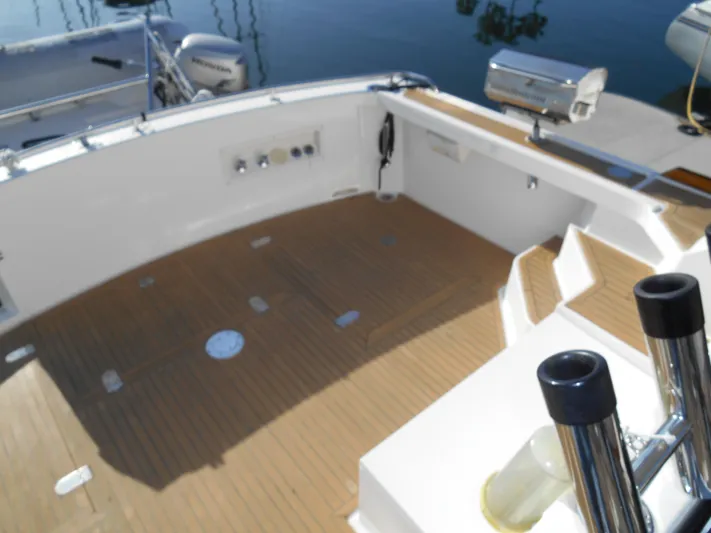 Balmy Yacht Photos Pics 1999 Grand Banks 38 Eastbay EX boat deck with wooden flooring and fishing rod holders.