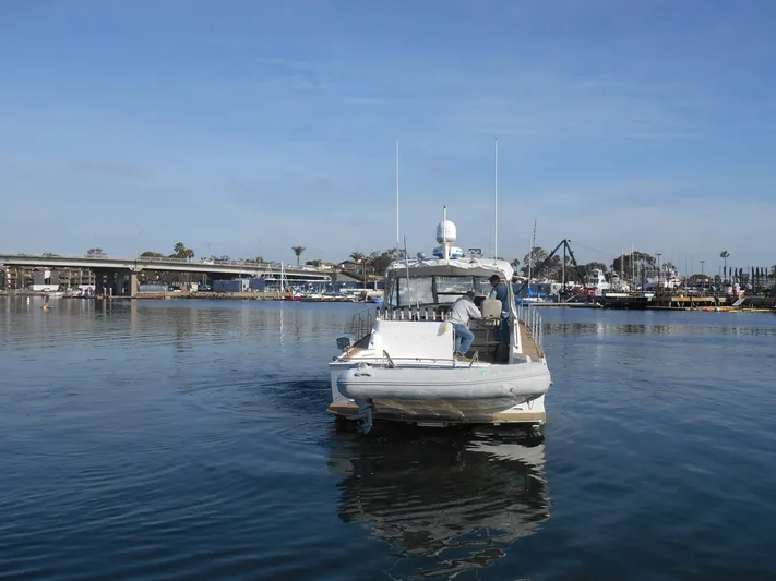 Balmy Yacht Photos Pics 1999 Grand Banks 38 Eastbay EX boat on calm water near a marina.