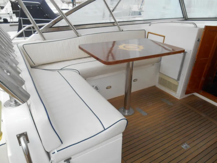 Balmy Yacht Photos Pics 1999 Grand Banks 38 Eastbay EX interior with cushioned seating and wooden table.