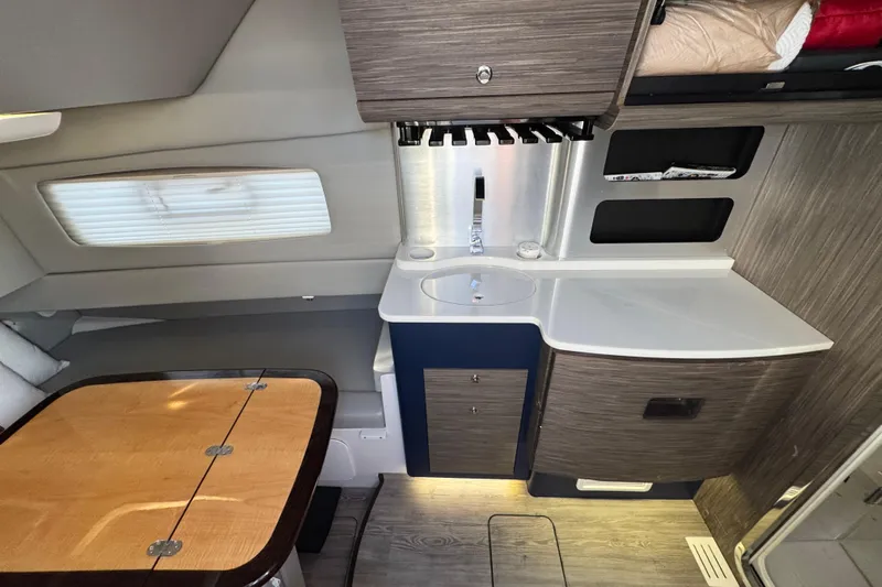  Yacht Photos Pics Interior of 2019 Scout 420 LXF boat featuring a compact kitchenette and dining area.