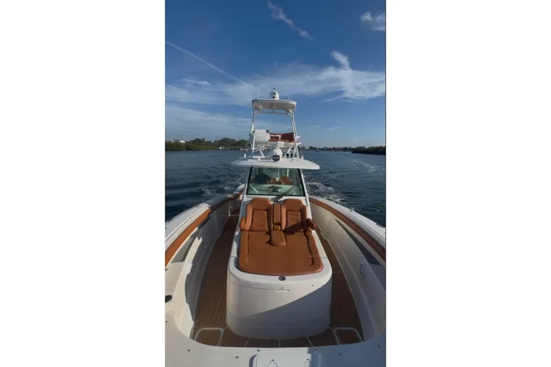  Yacht Photos Pics 2019 Scout 420 LXF boat cruising on a calm waterway under a clear blue sky.