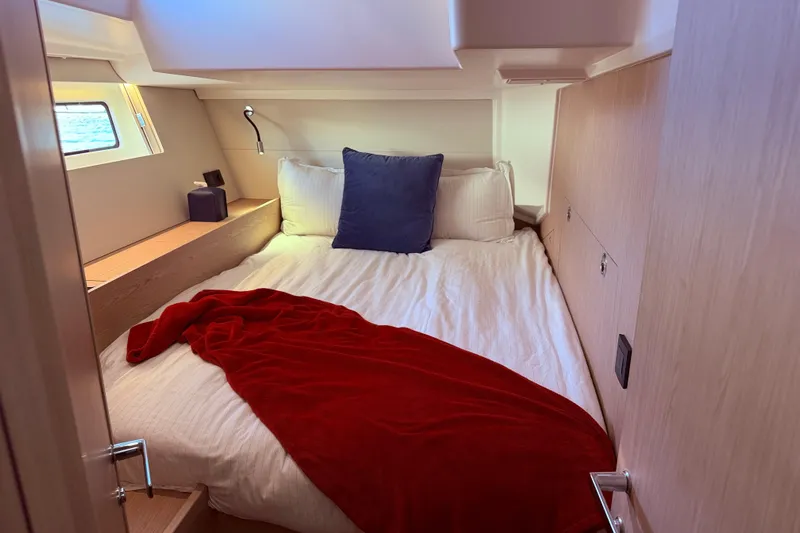 One Five Yacht Photos Pics Cozy cabin interior of 2022 Beneteau Oceanis Yacht 54 with bed and red blanket.