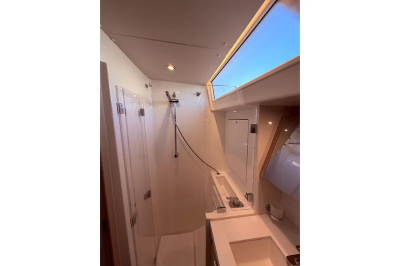 One Five Yacht Photos Pics Modern bathroom interior of 2022 Beneteau Oceanis Yacht 54 with skylight and shower.