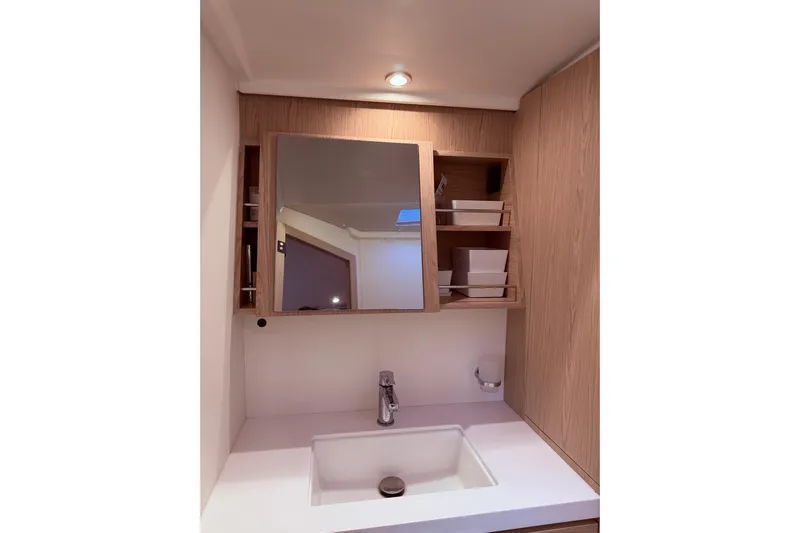 One Five Yacht Photos Pics Modern bathroom vanity in 2022 Beneteau Oceanis Yacht 54, featuring sleek sink and wooden cabinetry.
