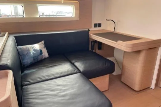 One Five Yacht Photos Pics Interior of 2022 Beneteau Oceanis Yacht 54 with leather seating and wooden desk.