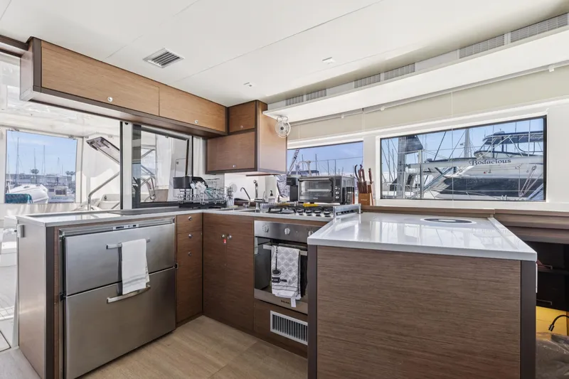 Second Wind Yacht Photos Pics Modern kitchen interior of 2022 Lagoon 52 F yacht, featuring sleek cabinetry and appliances.