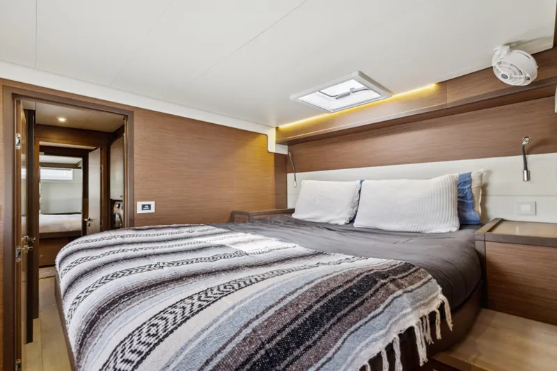 Second Wind Yacht Photos Pics Luxurious cabin interior of 2022 Lagoon 52 F yacht with cozy bedding and modern design.