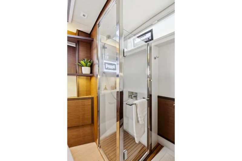 Second Wind Yacht Photos Pics Luxurious bathroom interior of 2022 Lagoon 52 F yacht with modern shower and wooden accents.