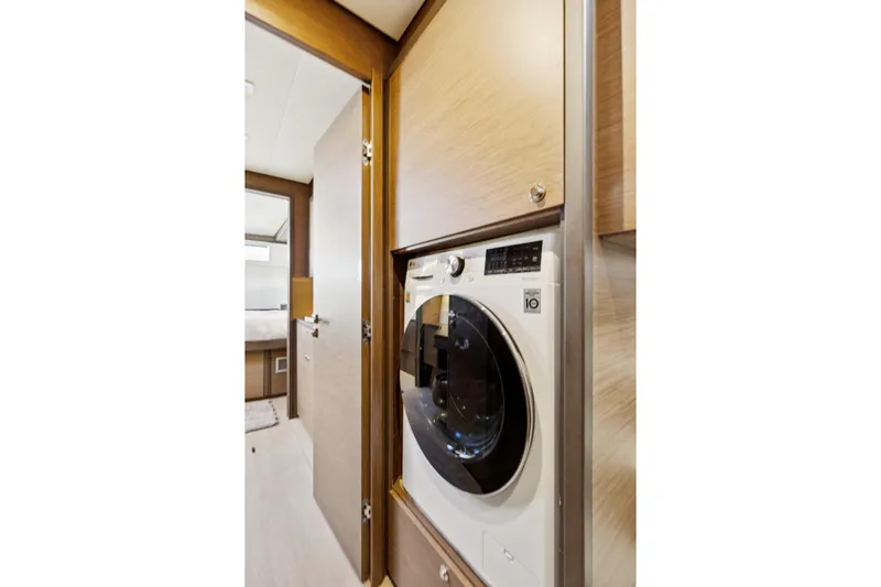 Second Wind Yacht Photos Pics Laundry area inside 2022 Lagoon 52 F yacht, featuring a modern washing machine.