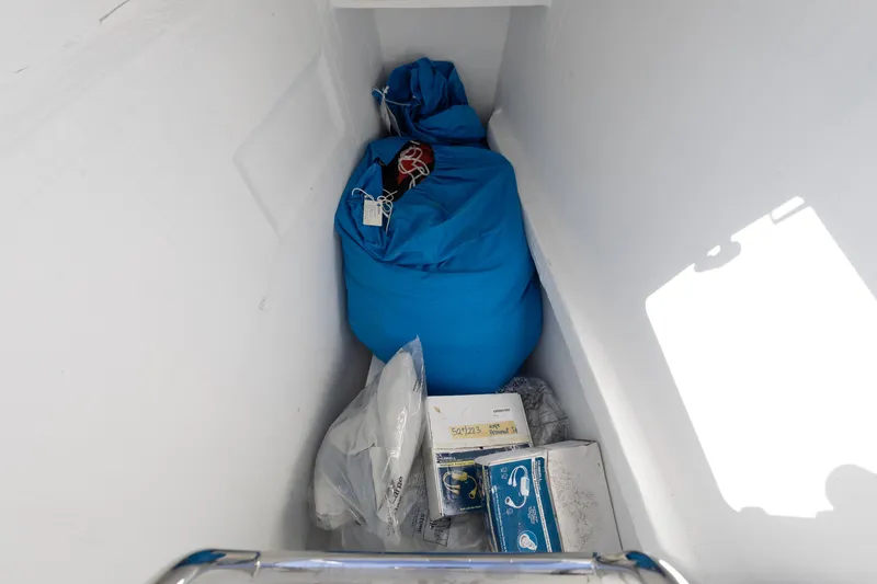 Second Wind Yacht Photos Pics Storage compartment on 2022 Lagoon 52 F yacht with blue bag and boxes.