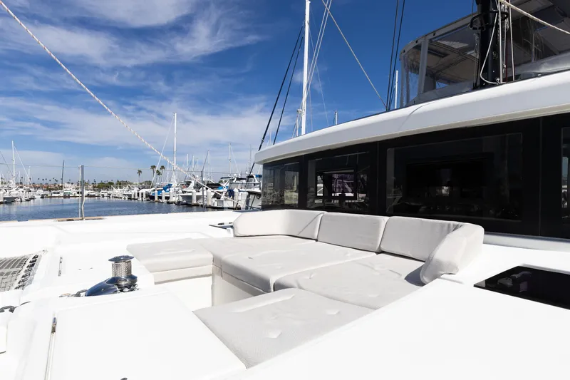 Second Wind Yacht Photos Pics Luxurious 2022 Lagoon 52 F yacht with spacious deck seating in a marina setting.