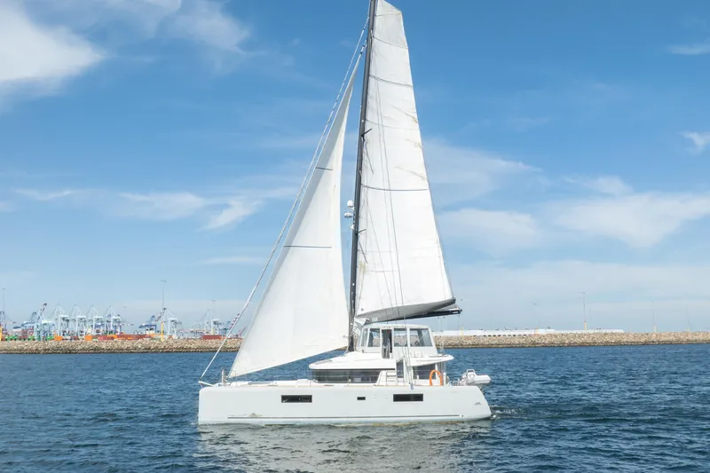 Second Wind Yacht Photos Pics 2022 Lagoon 52 F catamaran sailing on open water under clear blue skies.