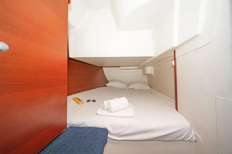  Yacht Photos Pics Cozy cabin interior of 2006 Hanse 400 yacht with neatly arranged bed and wooden accents.