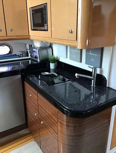  Yacht Photos Pics 2009 Four Winns 378 Vista yacht kitchen with sleek black countertop and modern appliances.