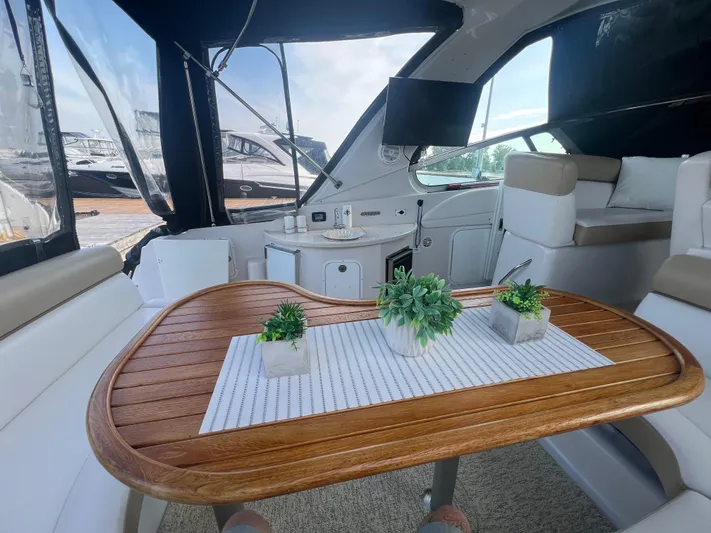  Yacht Photos Pics Interior of 2009 Four Winns 378 Vista yacht with wooden table and potted plants.