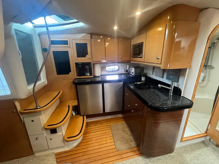  Yacht Photos Pics 2009 Four Winns 378 Vista yacht interior with modern kitchen and wooden cabinetry.