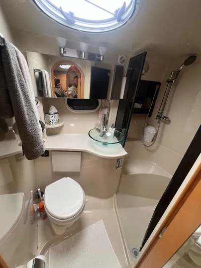  Yacht Photos Pics Compact bathroom in a 2009 Four Winns 378 Vista yacht, featuring modern fixtures and a circular window.