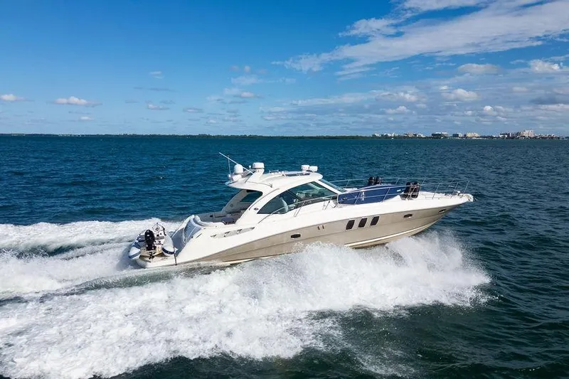  Yacht Photos Pics 2005 Sea Ray 48 Sundancer yacht cruising on open water under a clear blue sky.