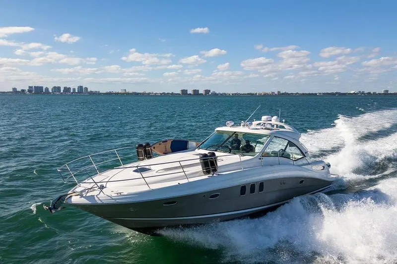  Yacht Photos Pics 2005 Sea Ray 48 Sundancer cruising on open water under a clear blue sky.