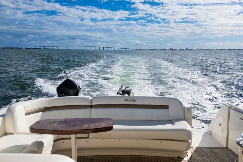  Yacht Photos Pics 2005 Sea Ray 48 Sundancer cruising on open water with bridge in background.