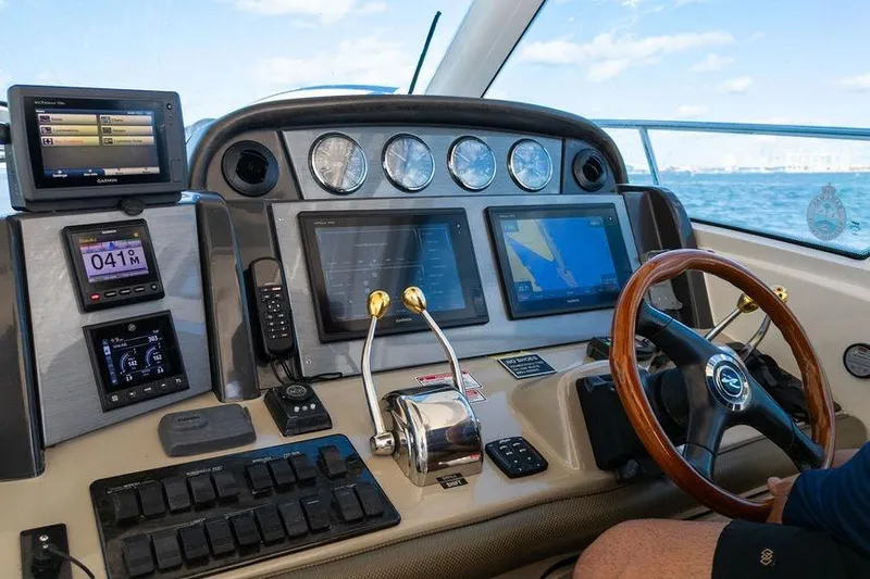  Yacht Photos Pics Helm of 2005 Sea Ray 48 Sundancer yacht with navigation instruments and steering wheel.