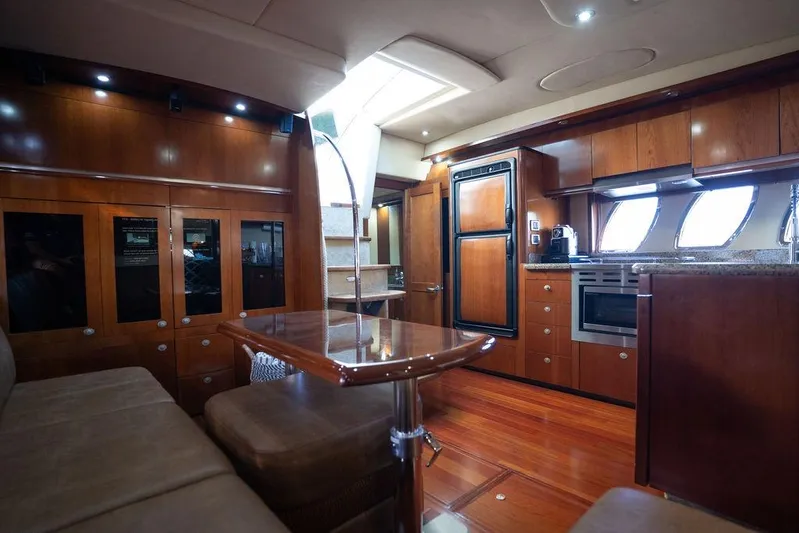  Yacht Photos Pics Luxurious interior of 2005 Sea Ray 48 Sundancer yacht with wood finishes and modern kitchen.