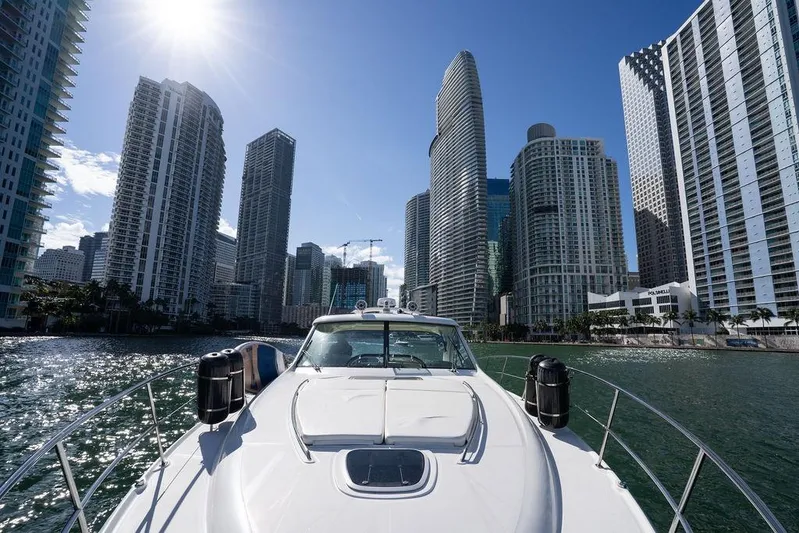  Yacht Photos Pics 2005 Sea Ray 48 Sundancer yacht cruising near city skyscrapers under a bright sun.