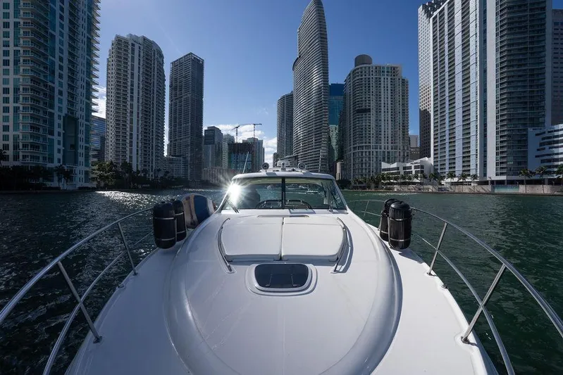  Yacht Photos Pics 2005 Sea Ray 48 Sundancer yacht cruising near urban skyscrapers on a sunny day.