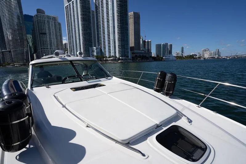  Yacht Photos Pics 2005 Sea Ray 48 Sundancer yacht cruising near city skyline on a sunny day.