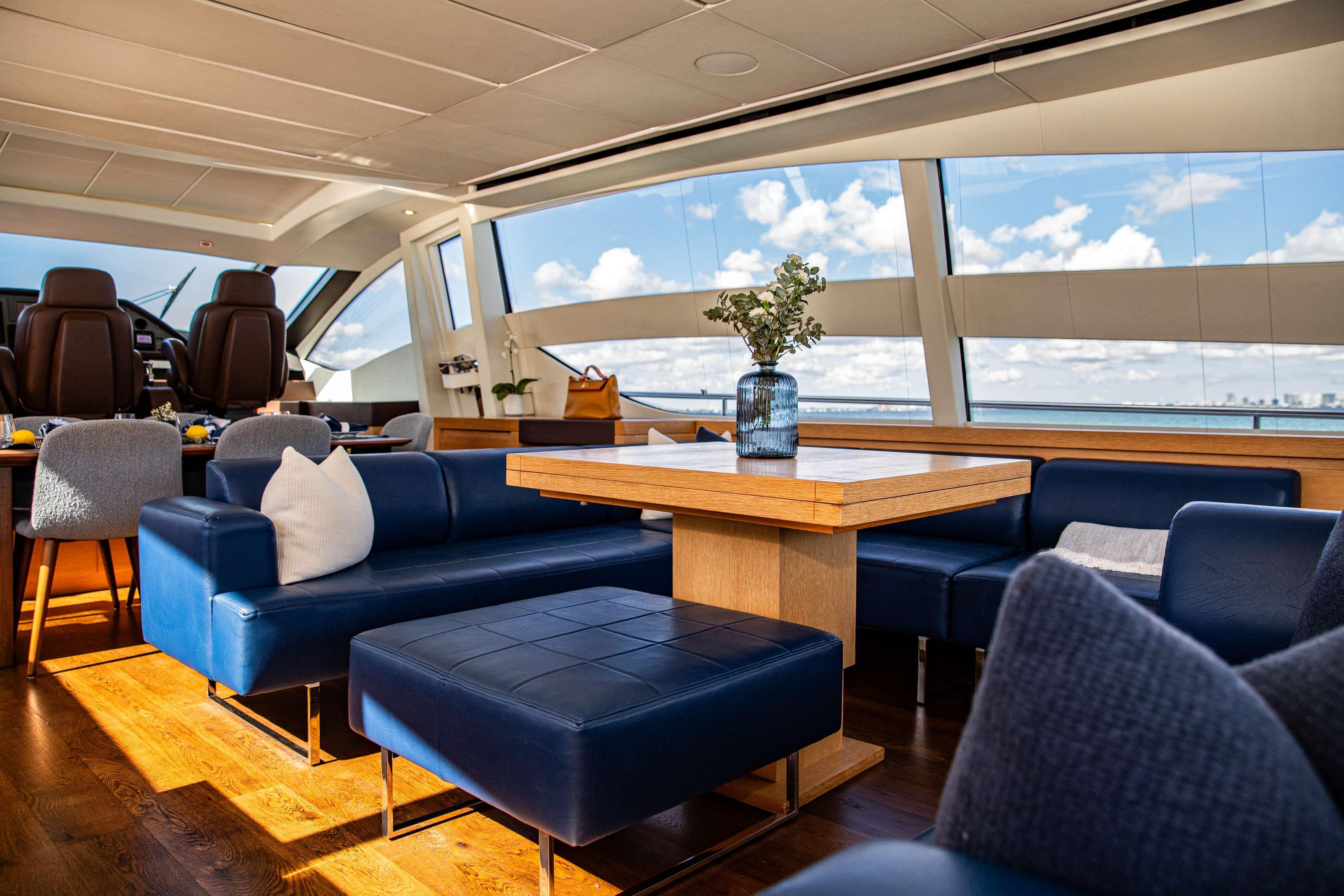 Luxurious interior of 2012 Pershing 82 yacht with blue seating and panoramic windows.