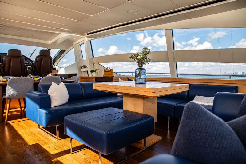 Dorothy Ann Yacht Photos Pics Luxurious interior of 2012 Pershing 82 yacht with blue seating and panoramic windows.