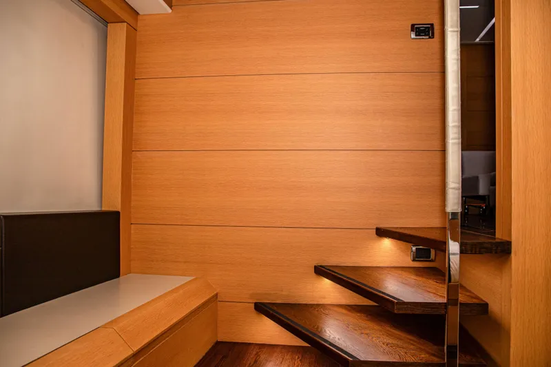 Dorothy Ann Yacht Photos Pics Interior of 2012 Pershing 82 yacht with modern wooden staircase and seating area.