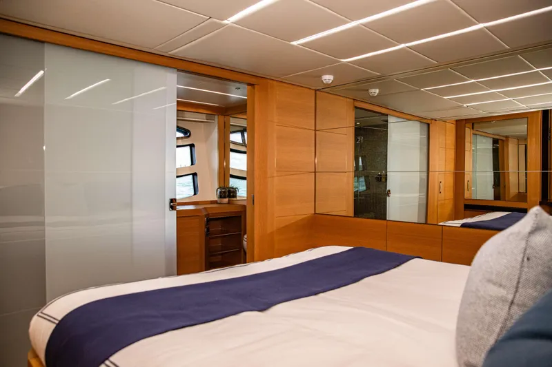 Dorothy Ann Yacht Photos Pics Luxurious bedroom interior of 2012 Pershing 82 yacht with modern wood and glass design.