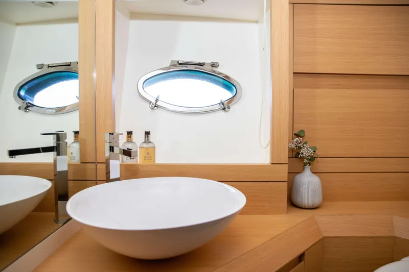 Dorothy Ann Yacht Photos Pics Luxurious bathroom on 2012 Pershing 82 yacht with modern sink and porthole window.