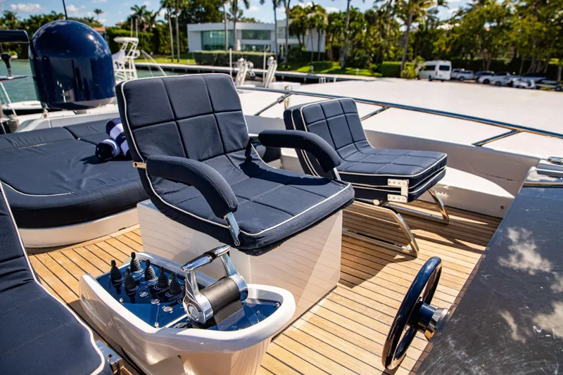 Dorothy Ann Yacht Photos Pics Luxurious seating on 2012 Pershing 82 yacht deck with control panel and steering wheel.