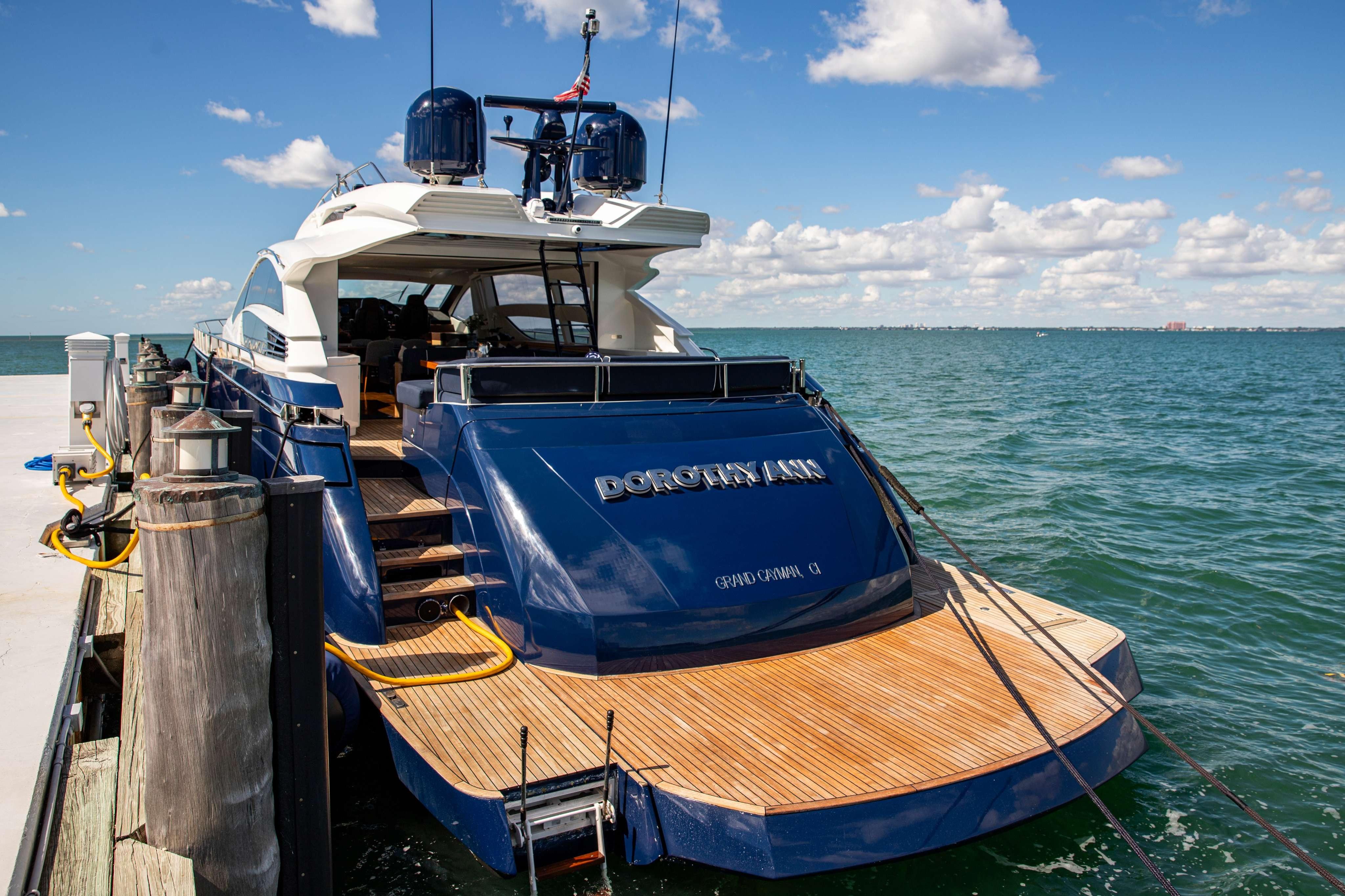 Luxury 2012 Pershing 82 yacht docked by the ocean under a clear blue sky.