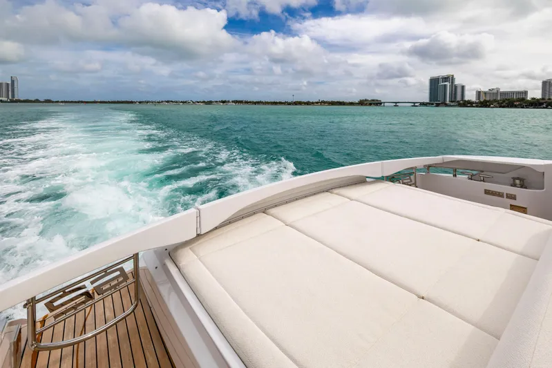 Sea Suite I Yacht Photos Pics 2021 Pershing 62 yacht cruising on turquoise waters with city skyline in the background.