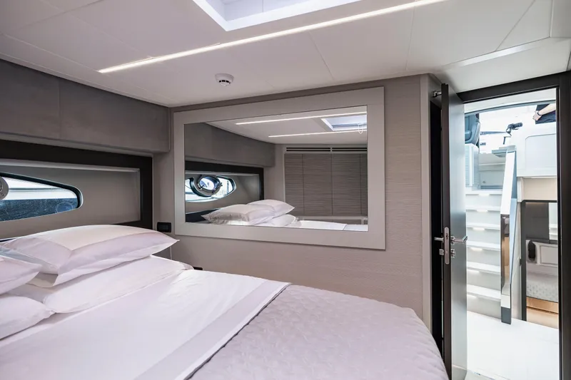 Sea Suite I Yacht Photos Pics Luxurious bedroom interior of 2021 Pershing 62 yacht with modern design and large mirror.