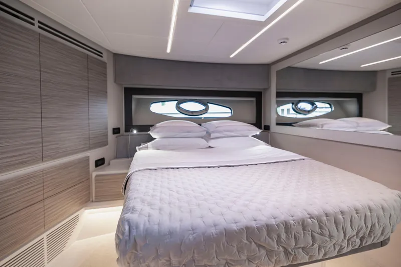 Sea Suite I Yacht Photos Pics Luxurious bedroom interior of 2021 Pershing 62 yacht with modern design and elegant bedding.