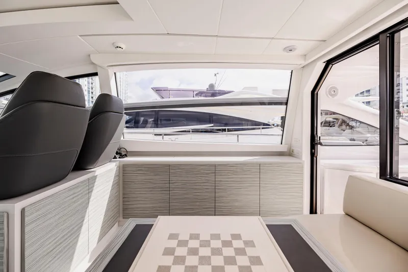 Sea Suite I Yacht Photos Pics Interior of 2021 Pershing 62 yacht, featuring modern seating and a chessboard table.