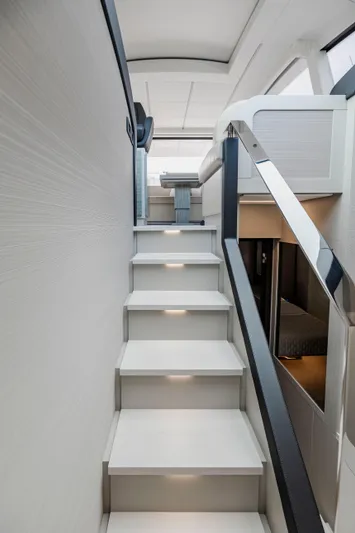 Sea Suite I Yacht Photos Pics Interior staircase of 2021 Pershing 62 yacht, featuring modern design and ambient lighting.