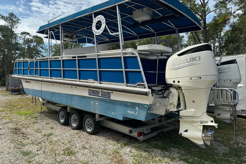  Yacht Photos Pics 1999 Catamaran Coaches 31 boat with Suzuki outboard engines on a trailer.