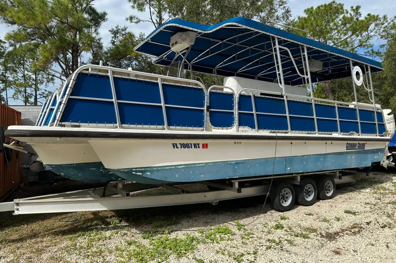  Yacht Photos Pics 1999 Catamaran Coaches 31 boat on trailer, blue and white, parked outdoors.