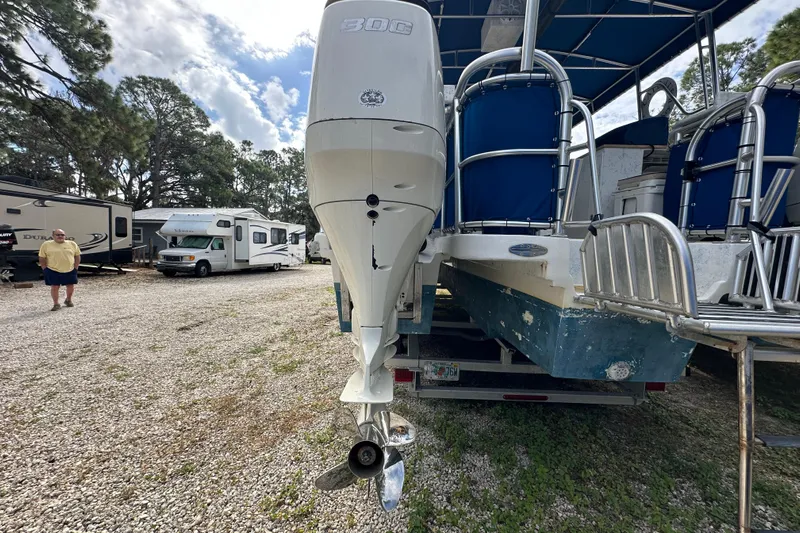  Yacht Photos Pics 1999 Catamaran Coaches 31 with outboard motor in a gravel lot, RVs in background.