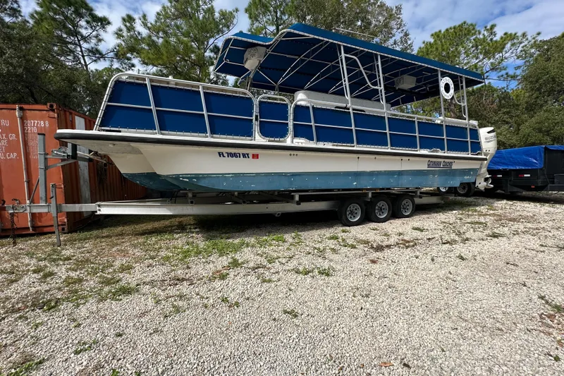  Yacht Photos Pics 1999 Catamaran Coaches 31 boat on trailer, blue canopy, parked outdoors.