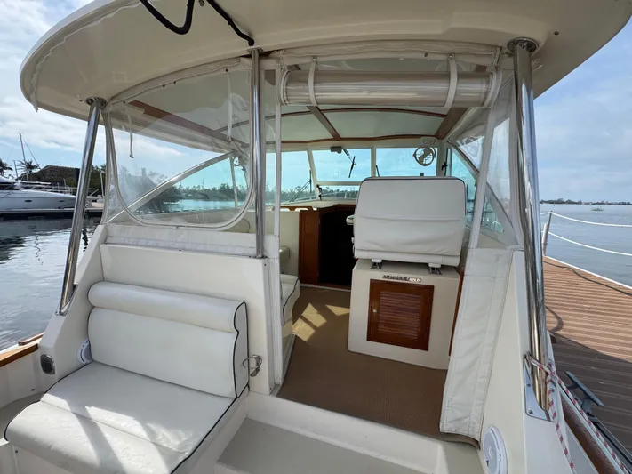 C'est La Vie Yacht Photos Pics 2010 Bruckmann Bluestar 29.9 boat interior with white seating and helm, docked by the water.